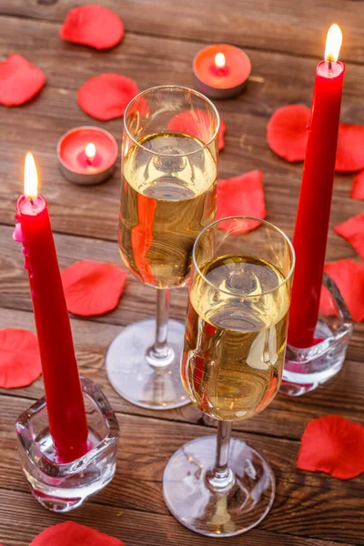 Romantic celebration with candles, champagne on wooden table