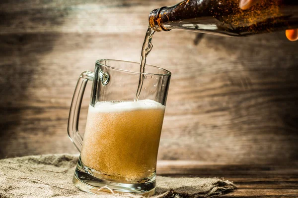 Αφρώδης Μπύρα Από Μπουκάλι Χύνεται Κούπα Στέκεται Καμβά — Φωτογραφία Αρχείου