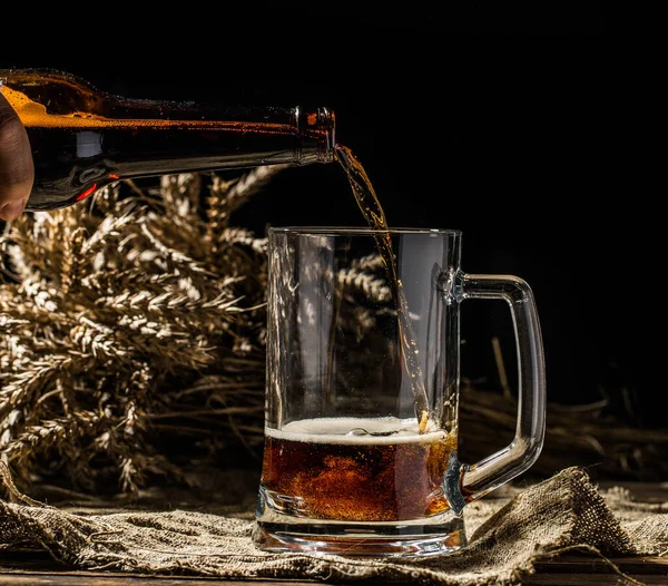 Пенное Пиво Бутылки Выливается Кружку Стоящую Пустом Деревянном Фоне — стоковое фото