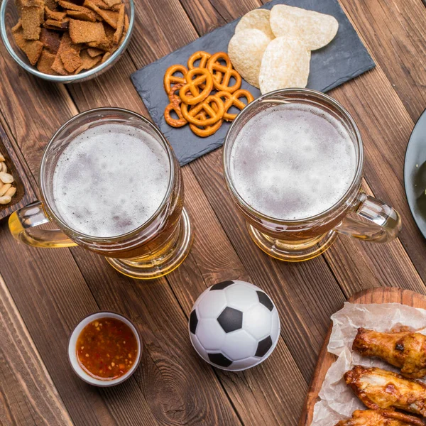 Appetizers and beer on the table for the football party and watch the football match.