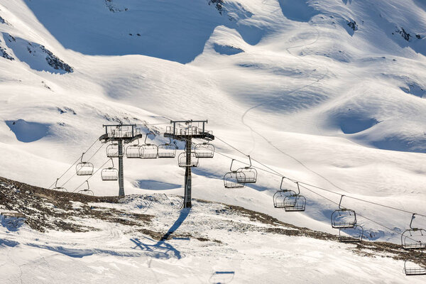 Photo of cable car cutting among snowy hills on winter day