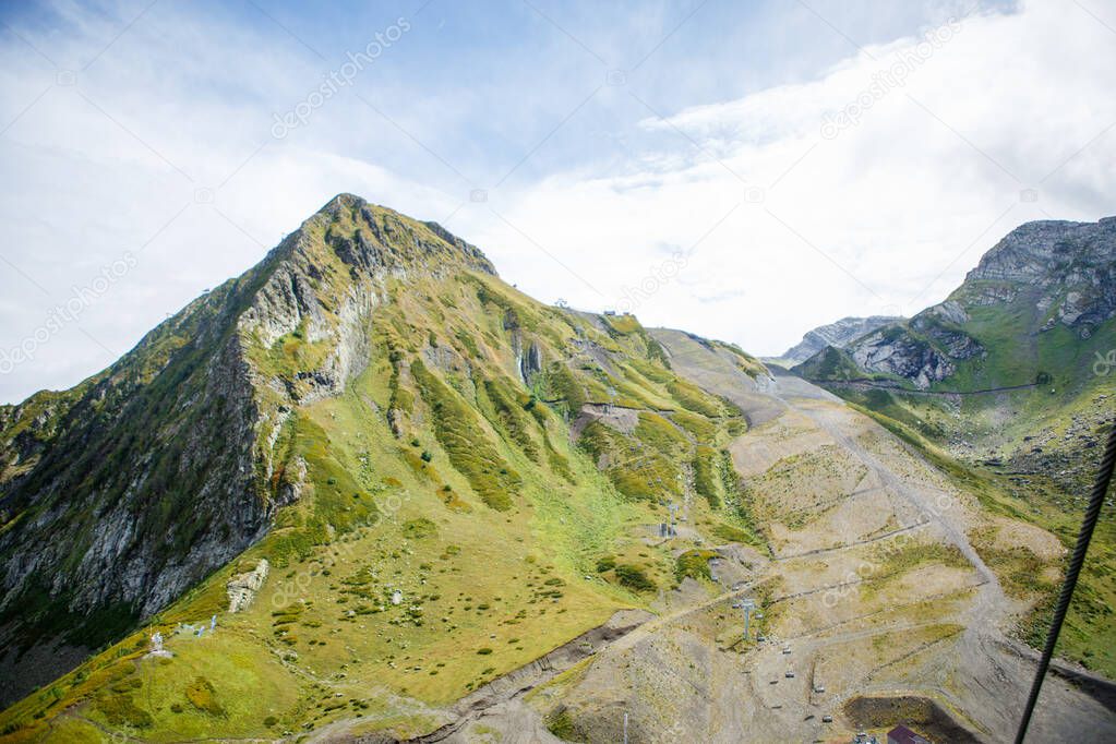 Photo of mountain slopes with vegetation and cloudy sky on summer day