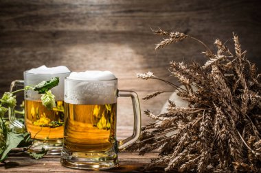 Masada birkaç bira ve boş ahşap arka planda çivi.