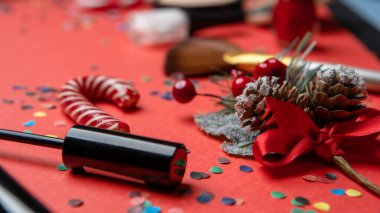 Fırça, konfeti, boş kırmızı masada noel süsü.