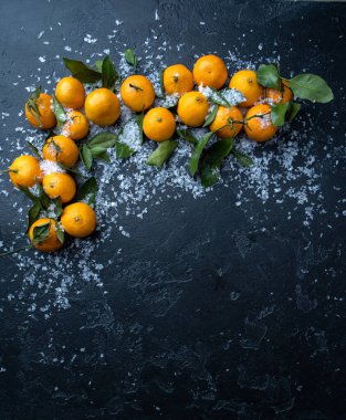 Siyah masada karlı mandalina fotoğrafı.