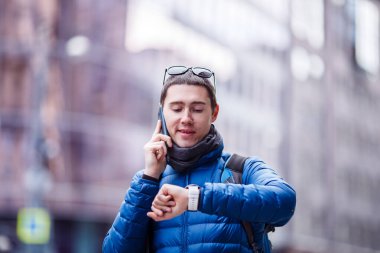 Telefonda konuşan ve şehirde akıllı adam arayan bir adam.