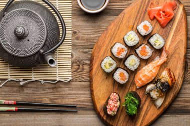 Lezzetli otantik Doğu mutfağı, suşi ve rulo ekmek ahşap yüzeyde servis edilir.
