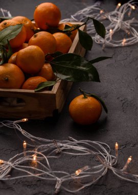 Ahşap kutuda mandalina resmi. Üzerinde yanan bir çelenk var.