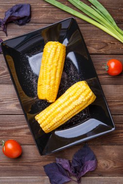 Tahta masadaki siyah tabakta mısır. Helthy yemeği..