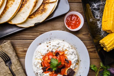 Quesadilla, süzme peynir ve domatesli salata, ahşap masada iki mısır. Top wiev. Taze yemek..