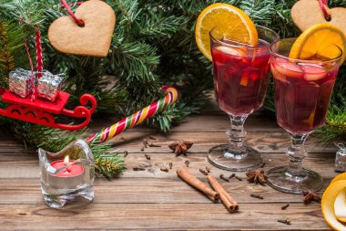 Portakallı, elmalı ve baharatlı iki bardak sıcak şarap. Noel arkaplanı.