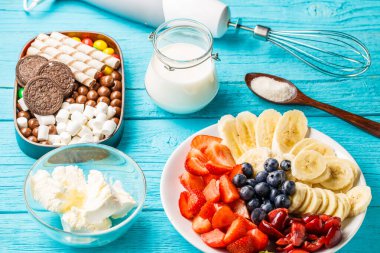 Mavi masadaki meyveli milkshake 'ler için malzemeler