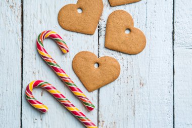 Noel geçmişleri. Tahta arka planda Noel dekoru, kurabiye ve bastonla. Yukarıdan görüntüle