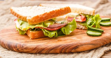 Taze ekmek, salata ve sosis. Mutfaktaki keten bezin üzerinde.