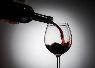 Şarap şişeden şarap kadehine boş bir arkaplandan dökülüyordu.