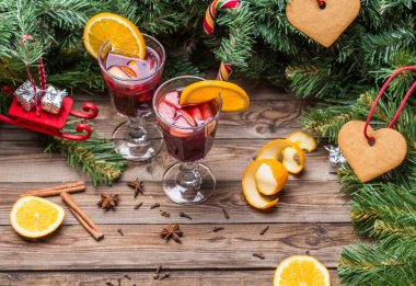 Portakallı, elmalı ve baharatlı iki bardak sıcak şarap. Noel arkaplanı.