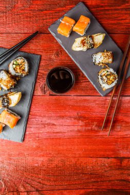 Kırmızı ahşap masada, kara tahtalarda servis edilir.