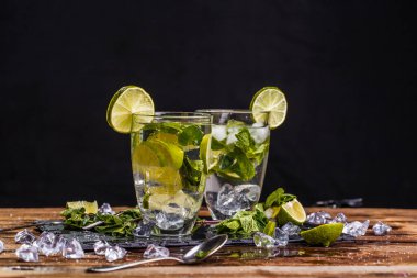 Siyah arkaplanda, tahta masada Mojito ile cam.