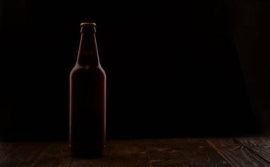 Tablodaki bira ve arkadaki siyah arkaplan fotoğrafı.