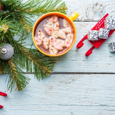 Bir fincan marşmelovlu kakao ve beyaz ahşap arka planda oyuncakları olan Noel ağacı. Yukarıdan görüntüle