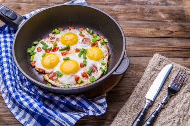 Tavada Fred yumurtası, domates ve taze soğan. Kahvaltıda. Sağlıklı yemek..