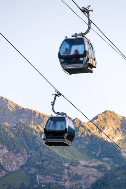 Yaz günü bitki örtüsü arasında dağ tepeleri arasında iki füniküyenin fotoğrafı
