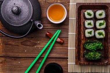 Köfteler, çaydanlık, soya sosu ve ahşap masa fotoğrafları.