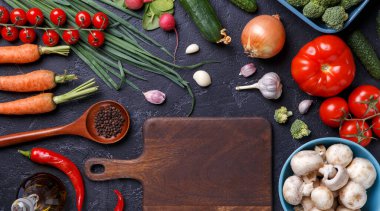 Taze sebzelerin, şampiyonların, kesme tahtasının ve tereyağının üstünde resim.