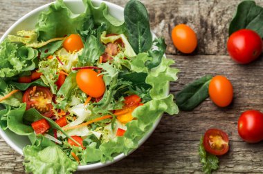 Taze sebze - domates, havuç, biber ve karışık yeşillik - roka salata, mesclun mache - ahşap arka plan üzerinde.