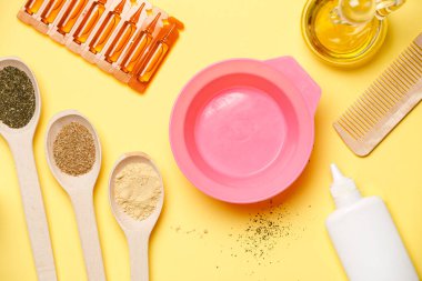 Yukarıdan pembe fincanlı fotoğraf, maske yağları, tahta kaşıklar, mavi masadaki taraklar.