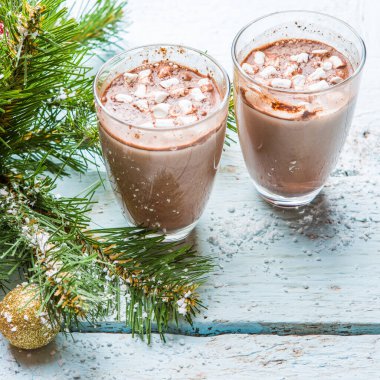 Bir fincan marşmelovlu kakao ve beyaz ahşap arka planda oyuncakları olan Noel ağacı..