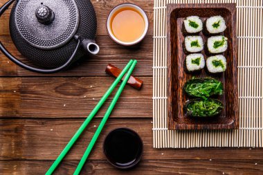 Çaydanlık çay, rulo, sopalar ahşap yüzeyde