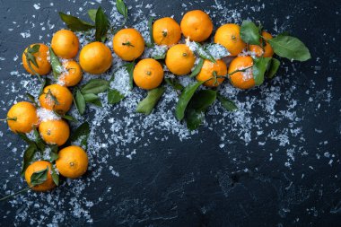 Siyah masada karlı mandalina fotoğrafı.