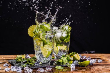 Mojito bardakları, sprey, ahşap masada limon.