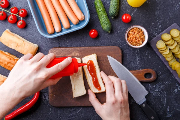 Zdjęcie Szczycie Stołu Składnikami Hot Dogów Deska Krojenia Męskie Dłonie — Zdjęcie stockowe