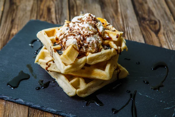 Birkaç Viyana waffle 'ının resmi. Çikolata, mandalina ve karatahtada dondurma.