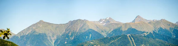 Panoramic photo of mountainous area with green vegetation against cloudy sky background