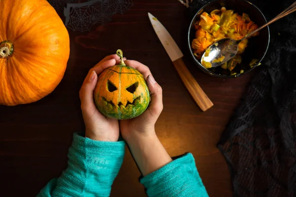 Zdjęcie Rąk Trzymających Latarnię Dyni Siedzącej Przy Drewnianym Stole Halloween — Zdjęcie stockowe
