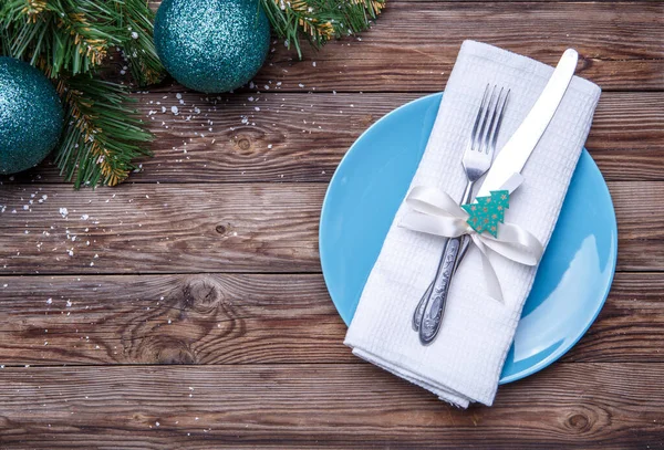 圣诞餐桌摆设为蓝色的盘子 叉子和刀 装饰过的缎带和带有冷杉玩具的蝴蝶结 白色餐巾和带有圣诞球的圣诞松树枝条 圣诞节背景 — 图库照片