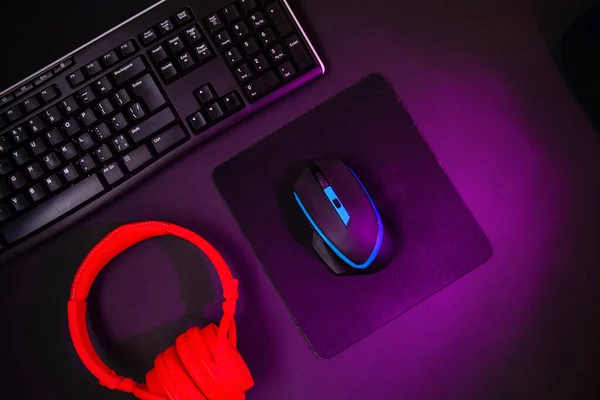 Top view a gaming gear, mouse, keyboard, joystick, headset, VR Headset on black table background. Gamer workspace concept.