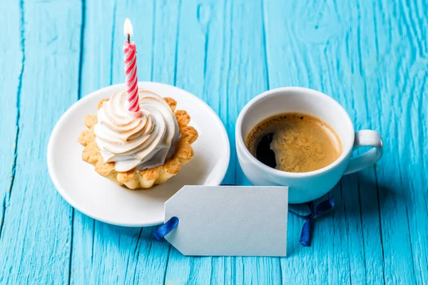 Kahve Fincanının Yanında Kremalı Pasta Yanan Mum Mavi Masada Boş — Stok fotoğraf