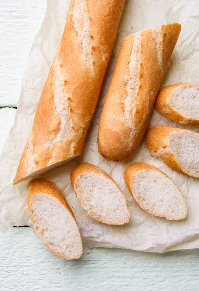 Färsk Lång Baguette Vitt Papper Träbord — Stockfoto