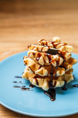 Ev yapımı waffle 'lar Mavi tabağa çikolata serpiştirir