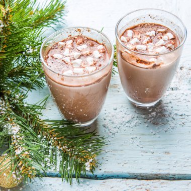 Bir fincan marşmelovlu kakao ve beyaz ahşap arka planda oyuncakları olan Noel ağacı..