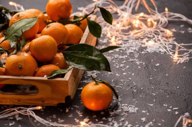 Ahşap kutuda mandalina resmi. Üzerinde yanan bir çelenk var.