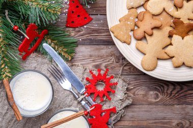 Noel içkisi, kurabiye ve tarçın şenlikli ahşap masada.