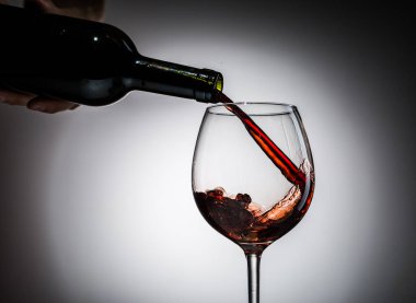Şarap şişeden şarap kadehine boş bir arkaplandan dökülüyordu.