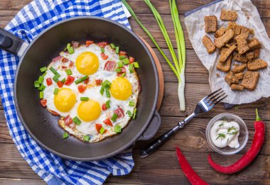 Tavada Fred yumurtası, domates ve taze soğan. Kahvaltıda. Sağlıklı yemek..