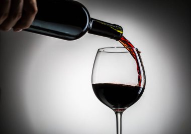 Şarap şişeden şarap kadehine boş bir arkaplandan dökülüyordu.