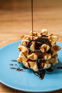 Ev yapımı waffle 'lar Mavi tabağa çikolata serpiştirir